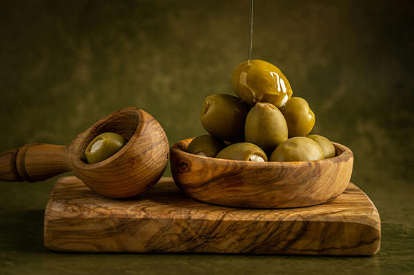 Olives on a board with oil being dripped on them
